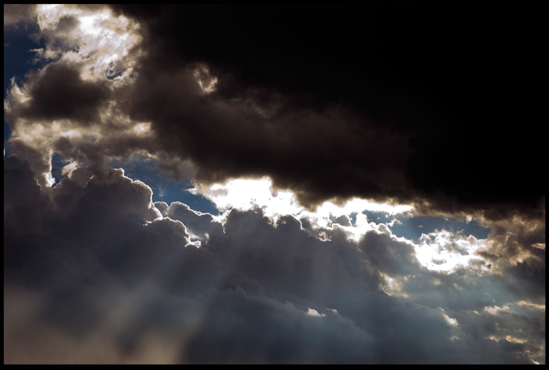 Photo of sun rays projecting light through the clouds